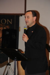 Bishop Gary Bryant speaking while holding a mic.