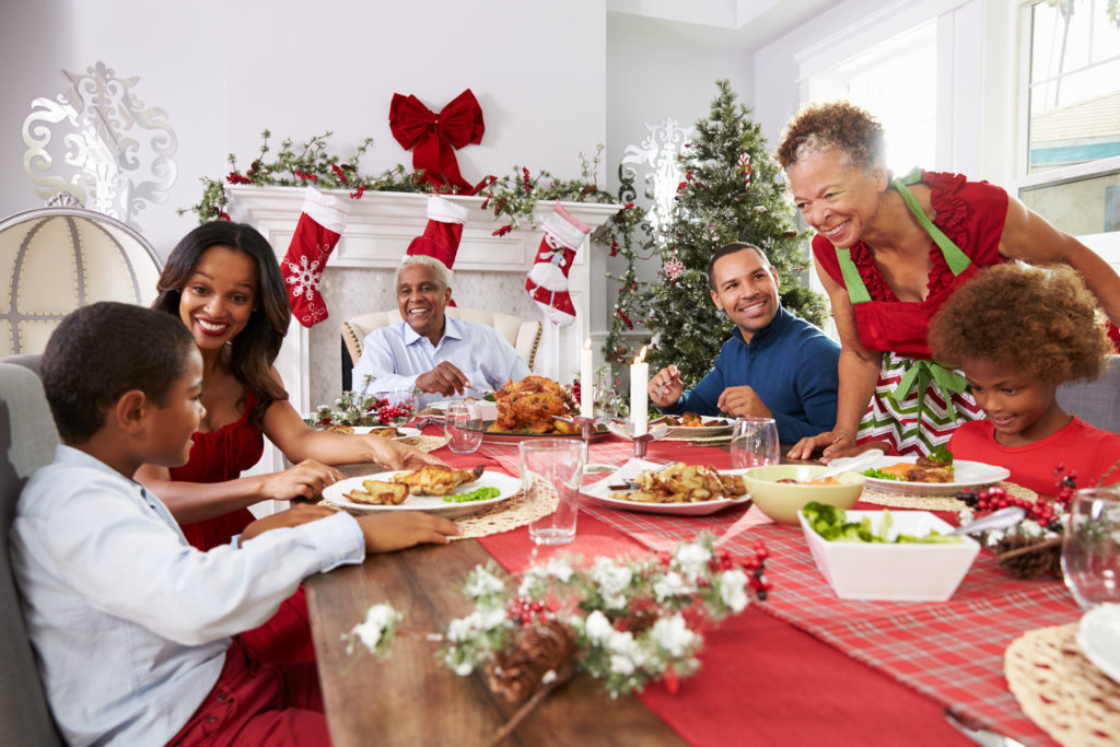 Family With Grandparents Enjoying Christmas Meal At Table