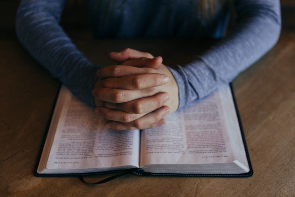 Praying hands on Bible