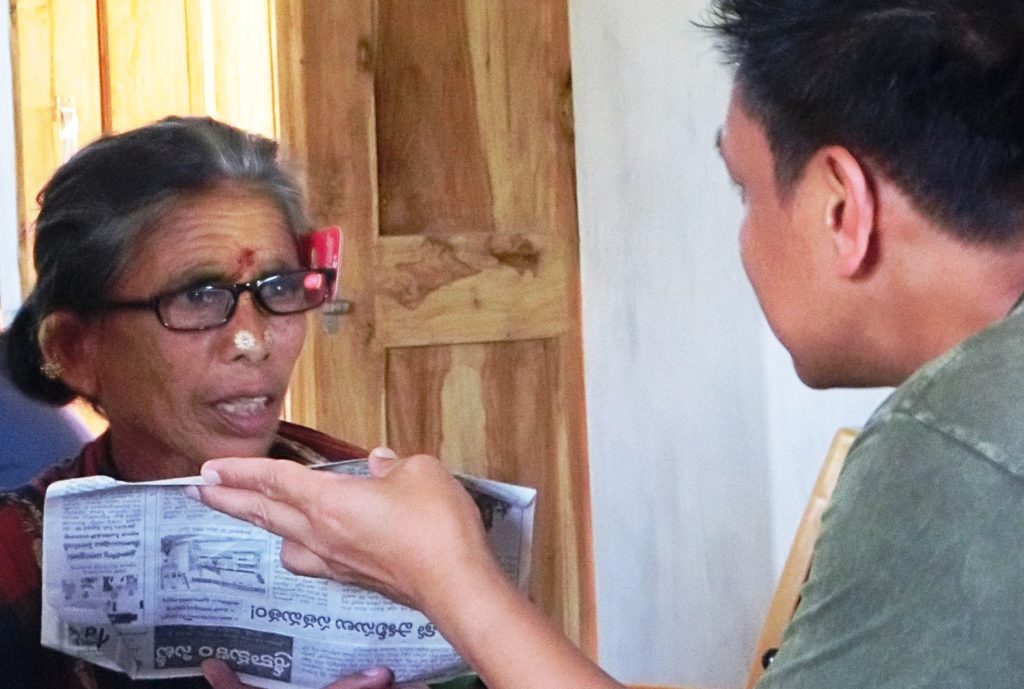 A Hindu lady trying out reading glasses at a medical clinic