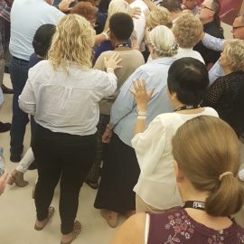 Missionaries praying at missionary gathering