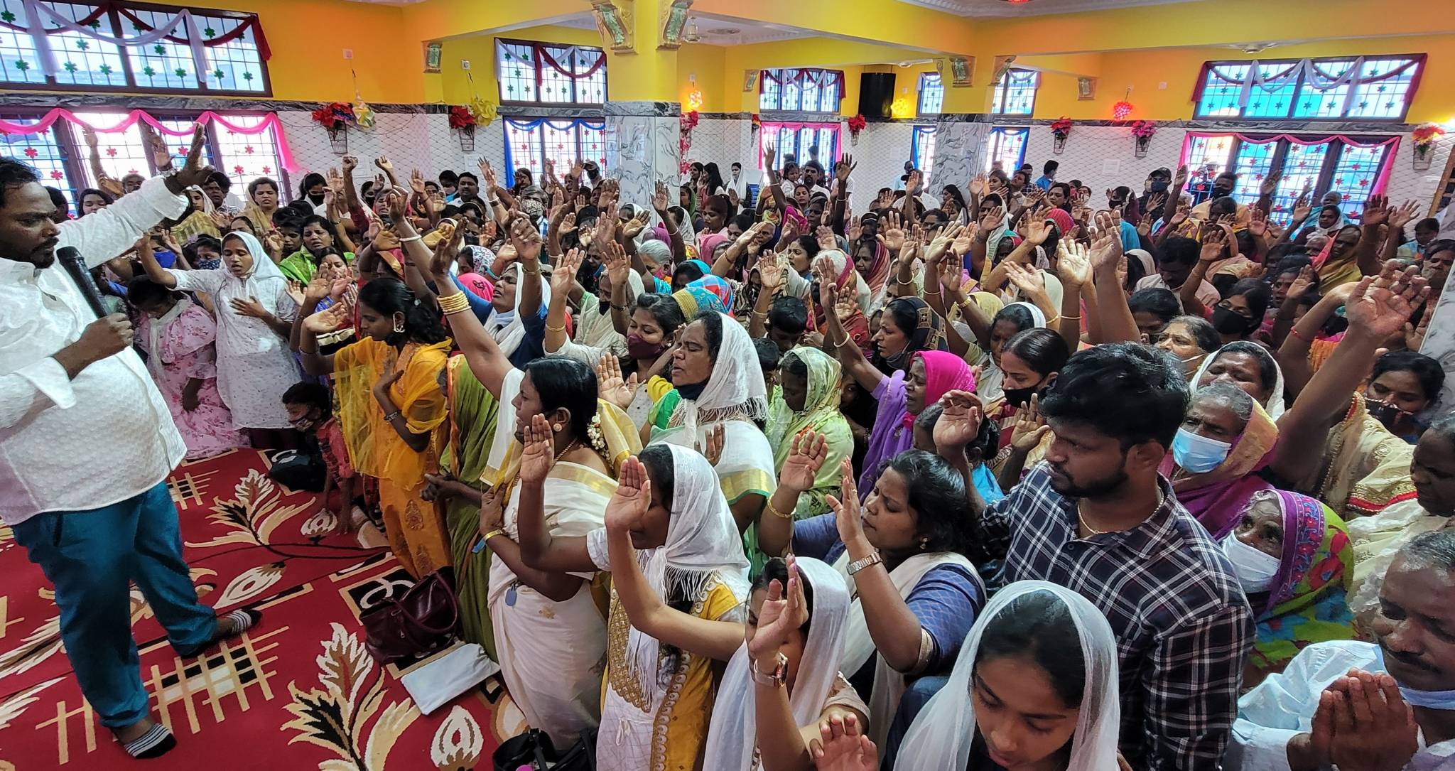 Abednego Leading a service of people with their hands raised. 