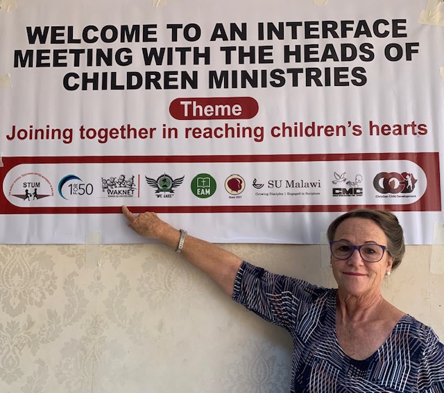 Althea posing with a Child Evangelism sign 