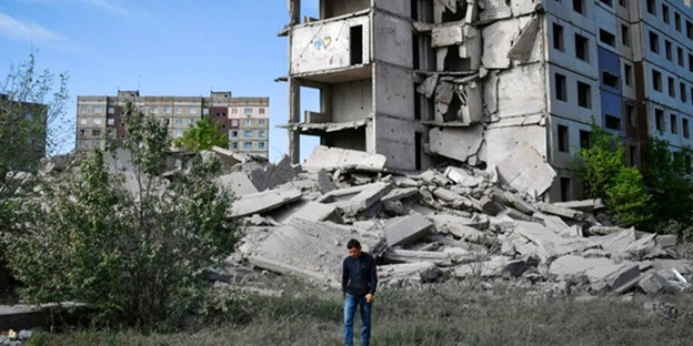 A local resident walks next to a house destroyed by Russian shelling in Kramatorsk, Ukraine, on Wednesday, May 25, 2022 (Andriy Andriyenko)