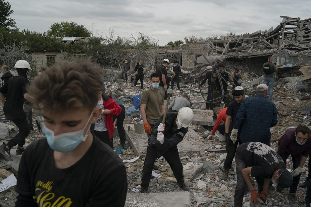Volunteers work to clean the debris on a site where several houses were destroyed after a Russian attack at a residential area in Zaporizhzhia, Ukraine, Sunday, Oct. 9, 2022. Russia has declared its intention to increase its targeting of Ukraine’s power, water and other vital infrastructure in its latest phase of the nearly 8-month-old war. (AP Photo/Leo Correa, File)