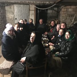Diana with her family in the Grandpa's basement. (Diana in green scarf far right)
