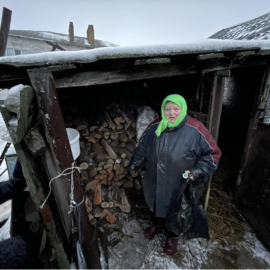 Woman gathering wood for the stove for warmth