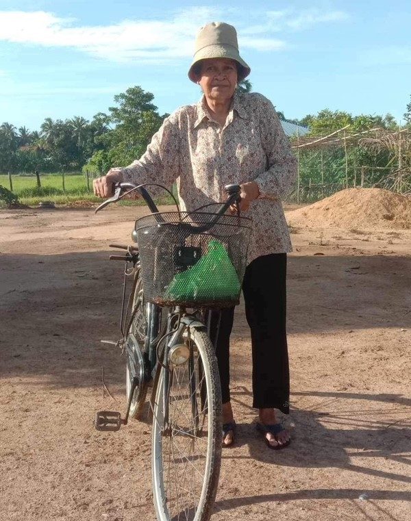 Leng Sok An with her bike, is ready to evangelize in thenext village.