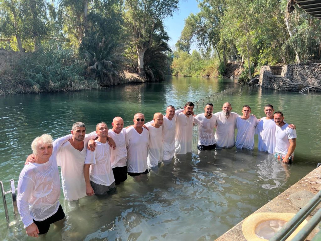 men and women from the feeding program standing in the Jordan River